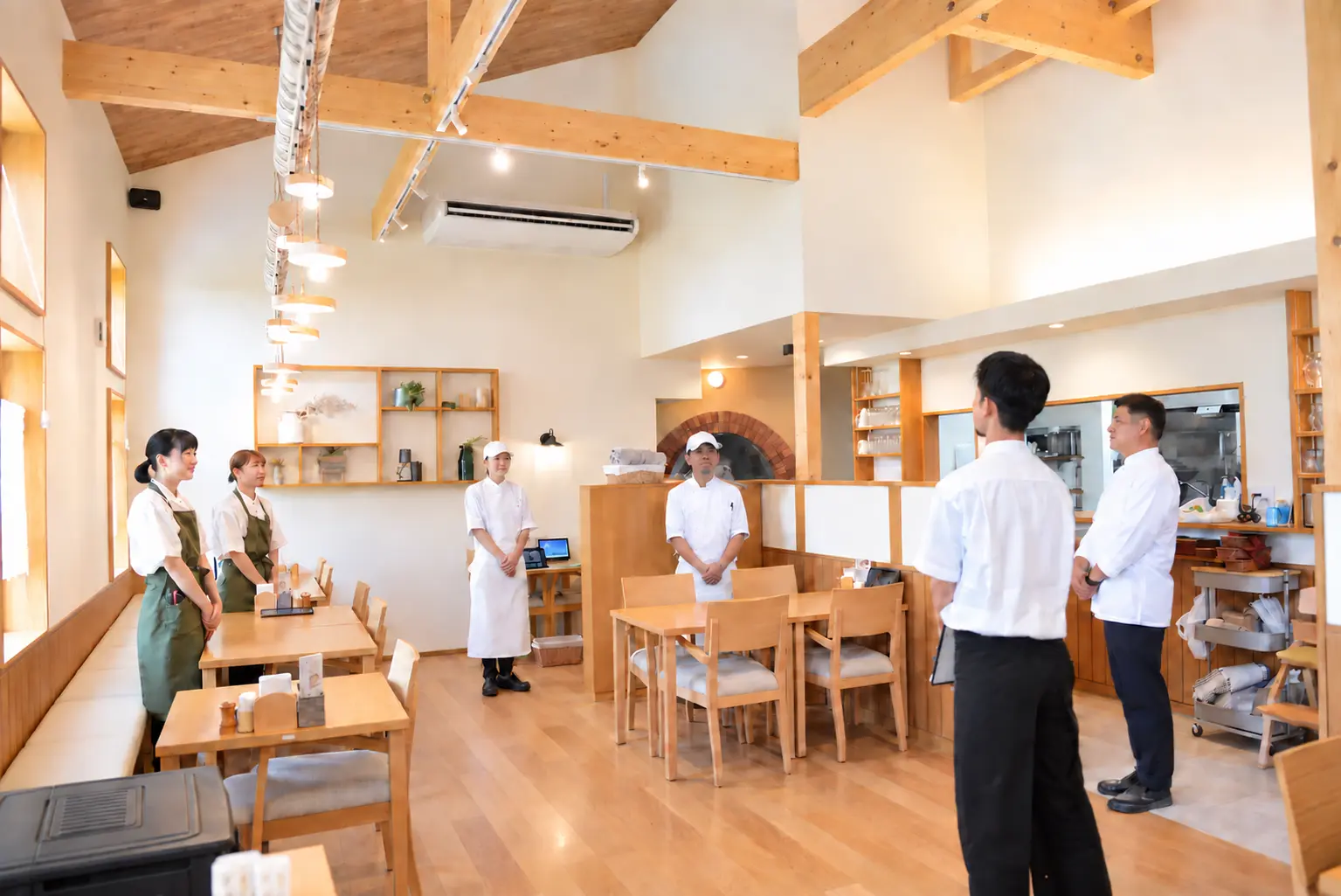 明るい店内で開店前の朝礼を行うエスペリオのスタッフ